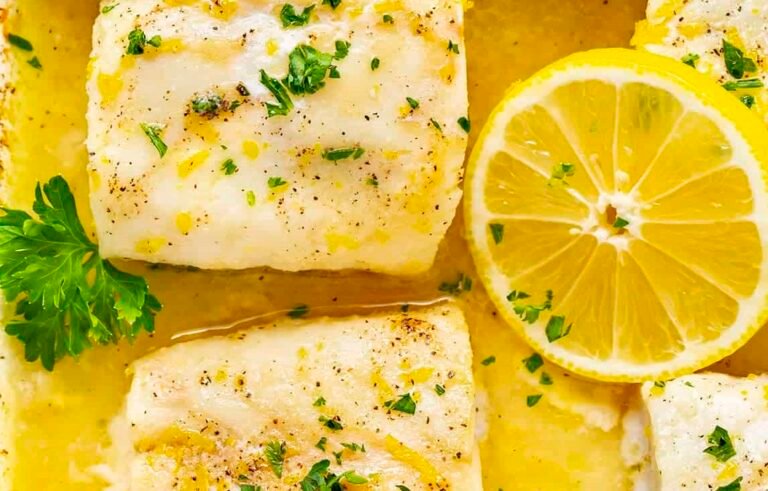 des filets de cabillaud cuits air fryer dans un plat décorées avec des rondelles de citron