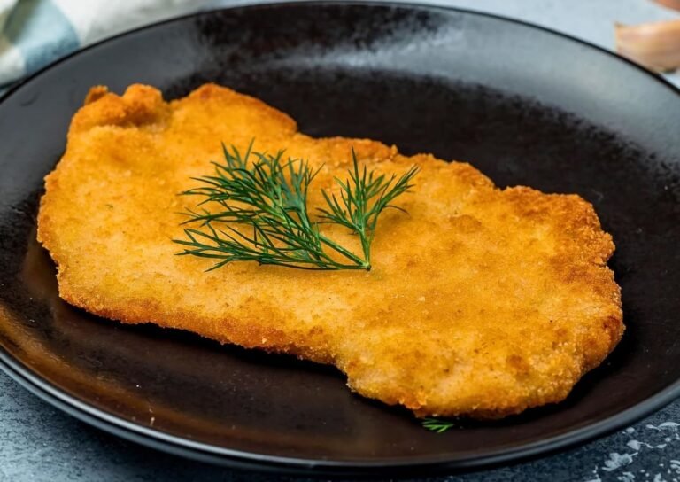 une escalope de veau panée dans une assiette noire