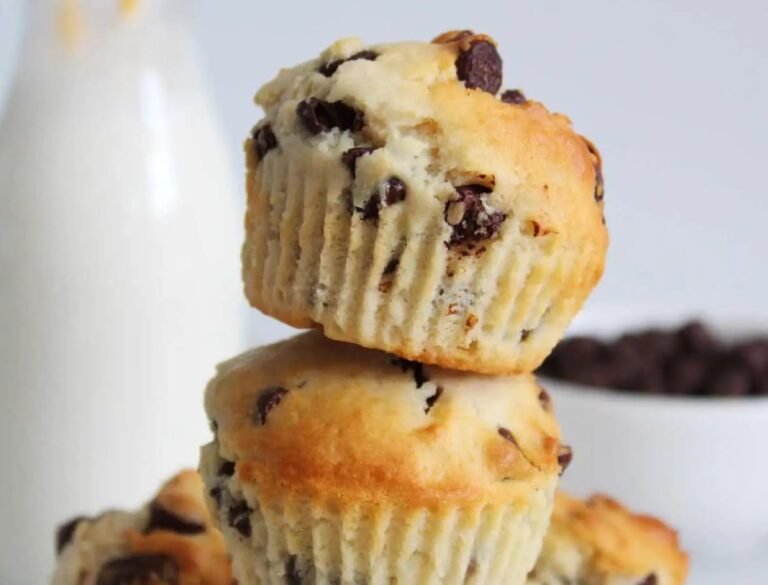 des muffins pepites de chocolat cuits au air fryer empilés. au second plan, une bouteille de lait et un bol de pepites