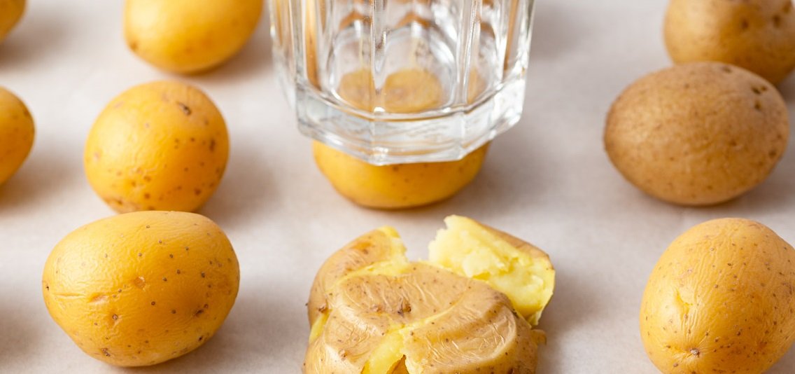 un verre qui écrase un pomme de terre avant de la passer au air fryer