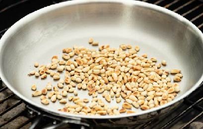 des pignons de pins grillés dans une poêle