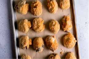 des champignons panés sur une plaque de cuisson